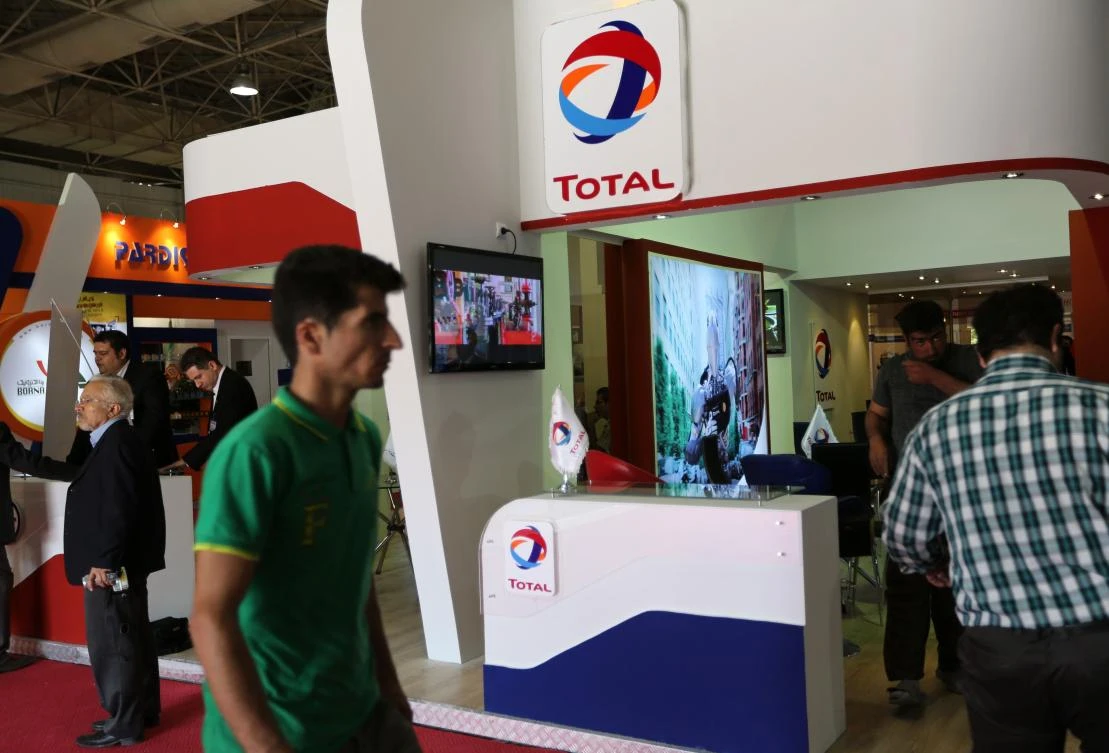 (FILES) This file photo taken on May 06, 2015 shows people walking past the stand of French oil and gas company Total during Iran's annual International Oil, Gas, Refining & Petrochemical Exhibition in Tehran. French energy giant Total is to sign a $4.8 billion deal to develop an Iranian offshore gas field, the oil ministry said on July 2, 2017, in the biggest foreign deal since sanctions were eased. (AFP)