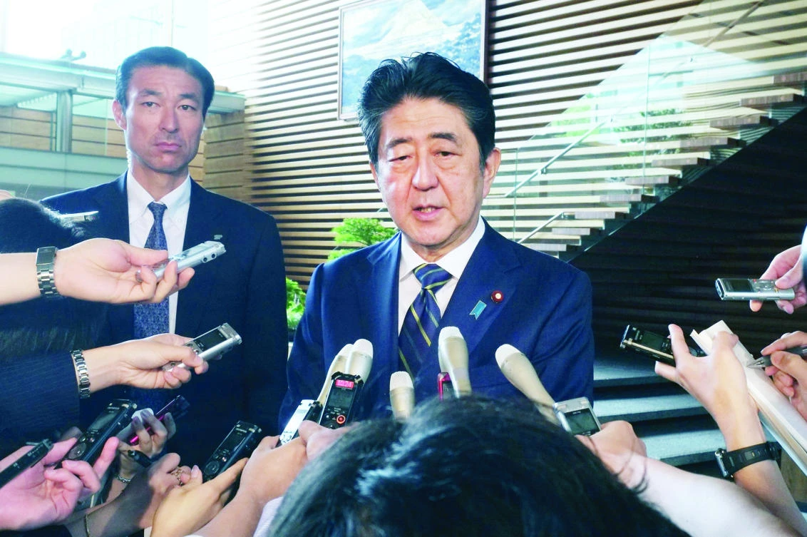 Japanese Prime Minister Shinzo Abe, center, speaks to the media upon arrival at his official residence in Tokyo on Monday. (AFP)