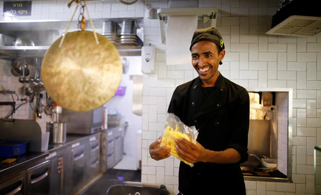An asylum seeker from Eritrea works in the kitchen of a restaurant in Tel Aviv, Israel. (Reuters)