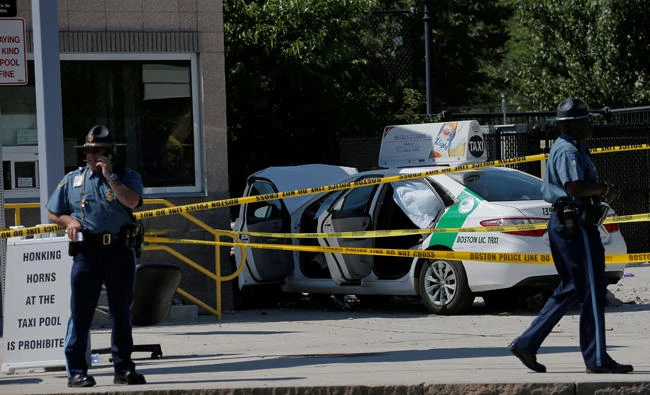 A Massachusetts State Police officer walks past the scene where a taxi cab crashed into a group of bystanders at the taxi pool at Logan International Airport in Boston, Massachusetts, US, on Monday. (REUTERS/Brian Snyder)