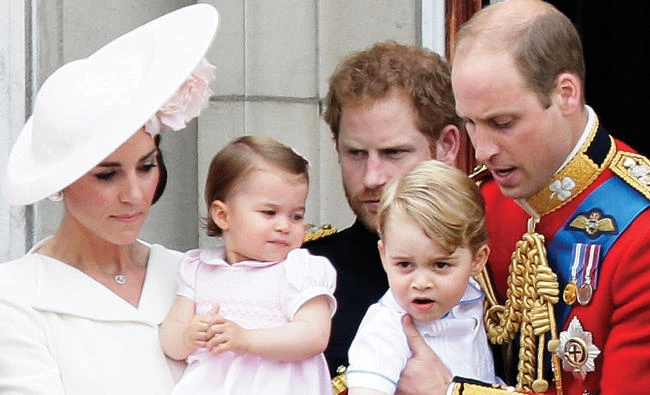 Prince William holding Prince George, right and Kate, Duchess of Cambridge holding Princess Charlotte, left.