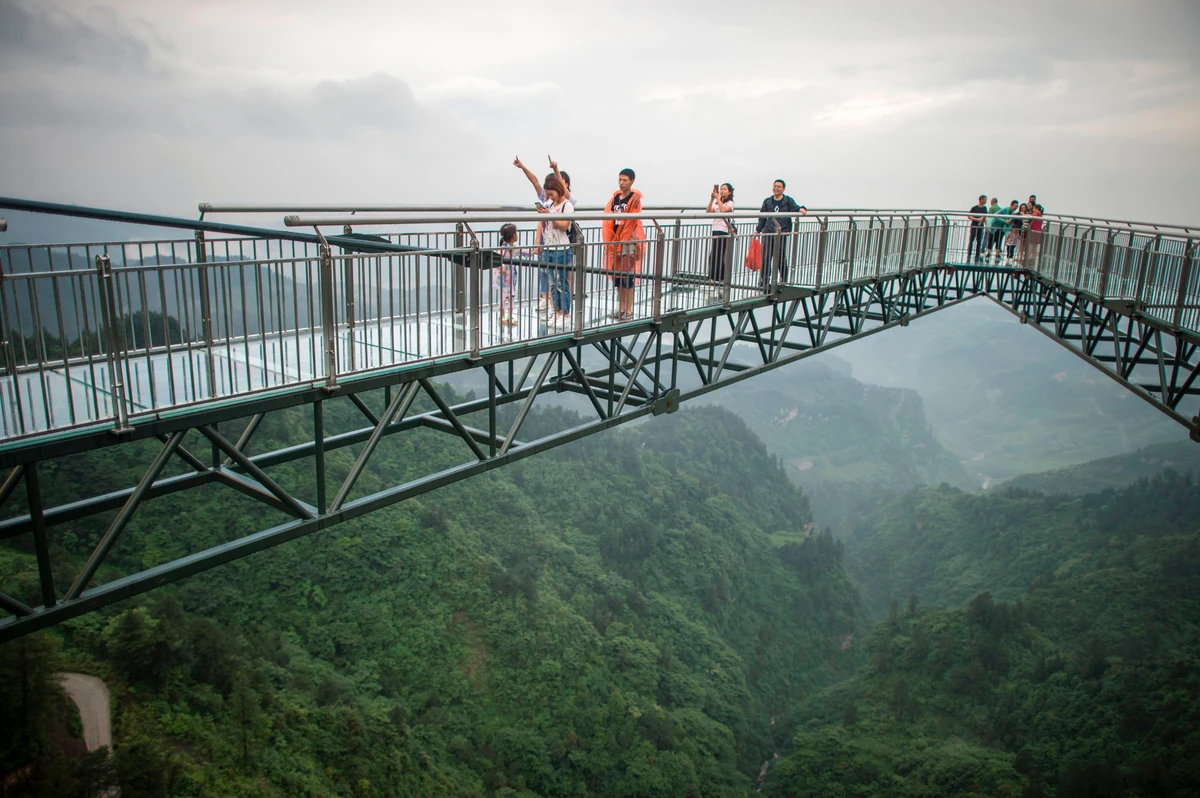 In this photo taken on June 1, 2017, tourists look on while standing on a glass-bottomed skywalk, certified as the world's longest, at the Ordovician park in Wansheng. Hovering more than 100 metres (328 feet) above a gaping chasm, a glass-bottomed skywalk has set a record in China while delighting and terrifying visitors. Guinness World Records certified the bridge in southwest Chongqing province as the longest cantilevered glass-bottomed skywalk on April 2, measuring at 69.6 metres (228 feet). (AFP)