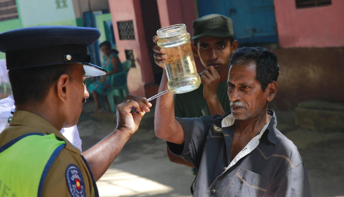 A Sri Lankan public health official,left, points out Mosquito lava in a bottle during a Dengue fever irradiation work in Colombo, Sri Lanka, Tuesday, July 4, 2017. Sri Lanka is suffering its worst dengue outbreak with more than 200 people killed and 76,000 infected this year. Alarmed by the scale of disease, the island nation has deployed hundreds of soldiers and police officers to clear away rotting garbage, stagnant water pools and other potential mosquito-breeding grounds. (AP)