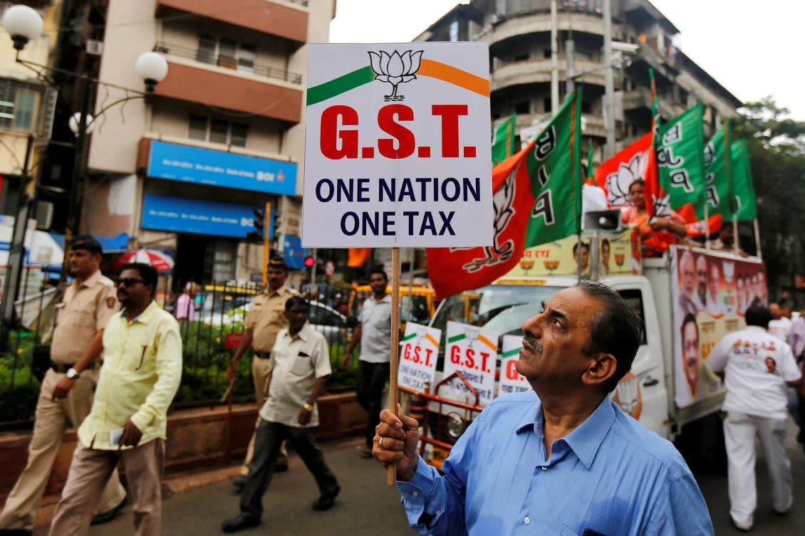 A supporter of India's ruling Bharatiya Janata Party (BJP) holds a placard during a rally to support implementation of the Goods and Services Tax (GST) in Mumbai, India, June 30, 2017. (REUTERS)