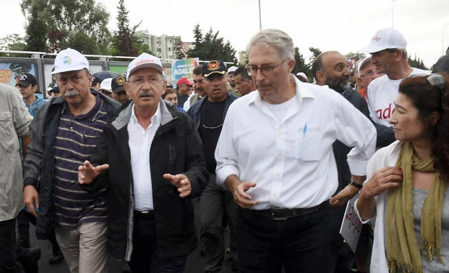 Kemal Kilicdaroglu, center, the leader of Turkey's main opposition Republican People's Party speaks to journalists as he walks in rain with thousands of supporters on the 20th day of his 425-kilometer (265-mile) " march for justice " in Izmit, Turkey, on Tuesday. (AP)