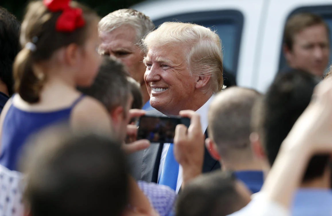President Donald Trump, center, smiles as he greets people at the Fourth of July picnic for military families on the South Lawn of the White House, Tuesday, July 4, 2017, in Washington. (AP)