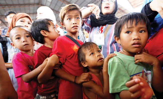 Children line up to receive lunch at an evacuation center outside the city as army troops continue their assault against insurgents from the Maute group in Marawi city, Philippines, on Wednesday. (Reuters)