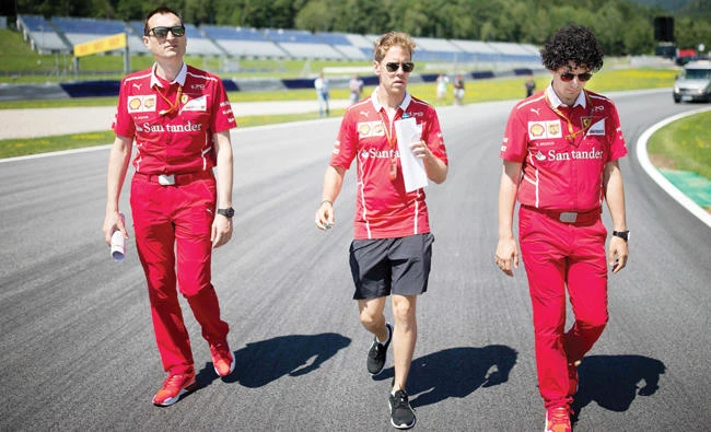 German Formula One Ferrari driver Sebastian Vettel, center, inspects racetrack ahead of the Austrian Formula One Grand Prix at the Red Bull Ring in Spielberg, Austria, on Thursday. (AFP)