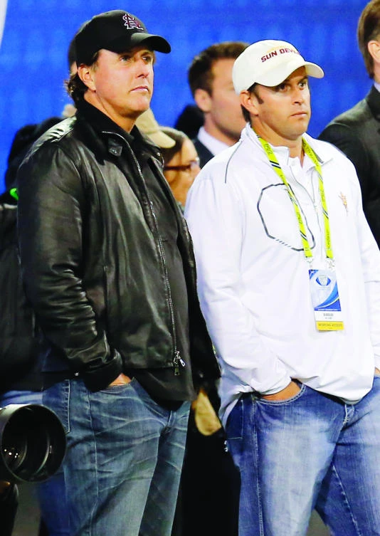 In this Dec. 7, 2013, file photo, PGA golfer Phil Mickelson, left, and his brother, Tim Mickelson, watch from the sidelines during the first half of the NCAA Pac-12 Championship football game between Arizona State and Stanford, in Tempe, Ariz. (AP)