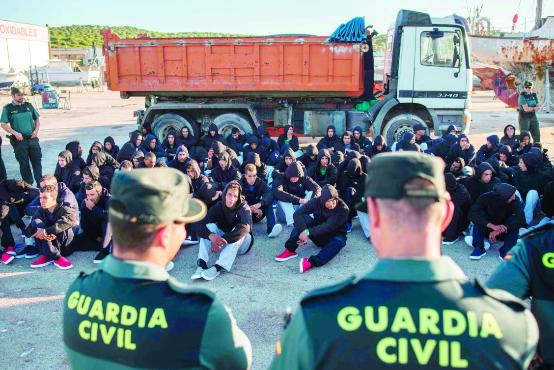 Moroccan migrants sit at the port of Barbate after being rescued in waters of the Strait of Gibraltar off the Spanish coast on Friday. (AFP)