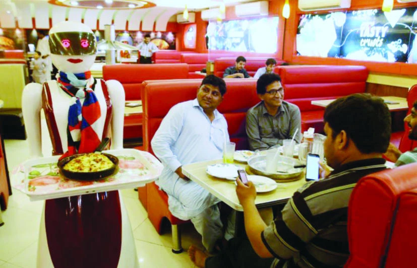 A robot waitress serves food to customers at a pizza restaurant in Multan, Pakistan. (AP)