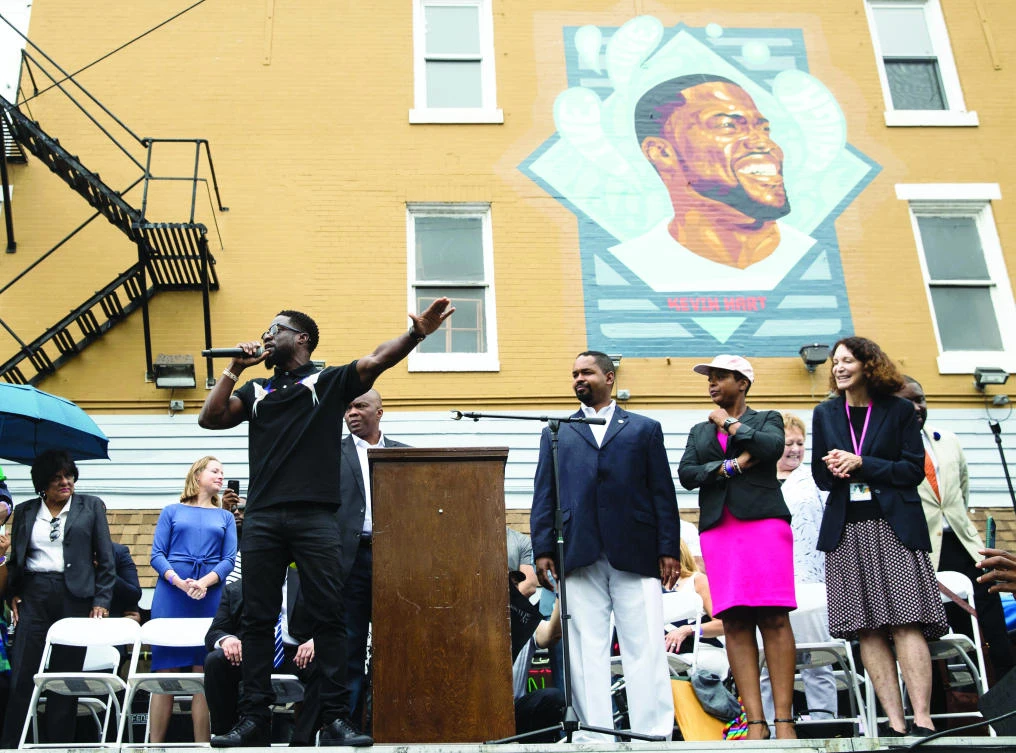 Actor-comedian Kevin Hart, left, speaks during the dedication of a mural honoring him on his birthday near his childhood home in Philadelphia, on Thursday. (AP)