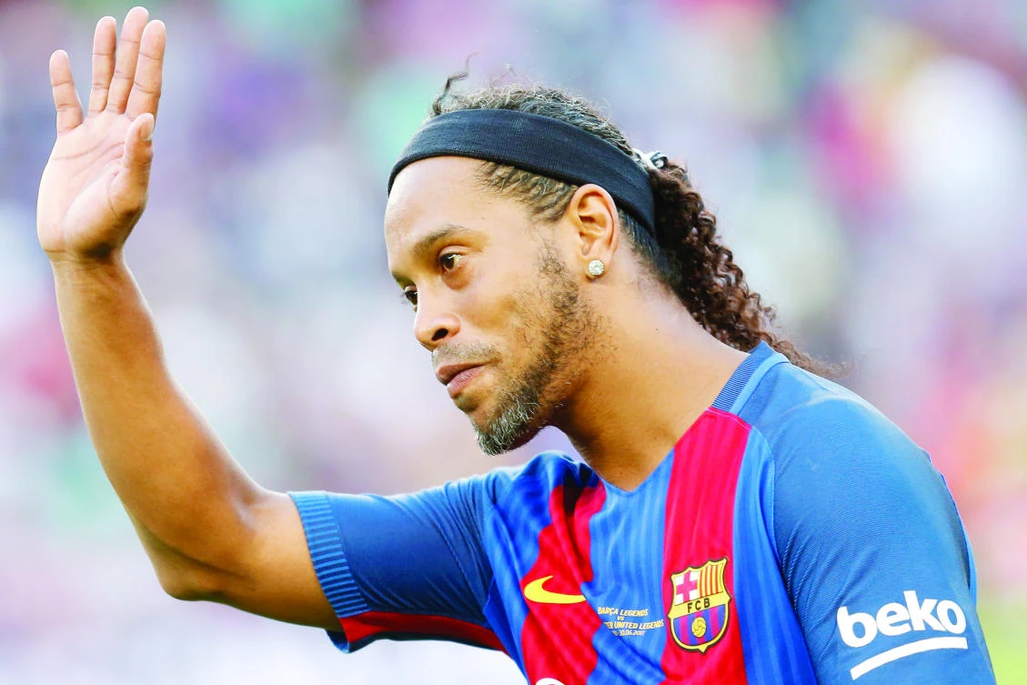 Former Barcelona's Brazilian forward Ronaldinho waves to spectators after a charity football match between Barcelona Legends and Manchester United Legends at the Camp Nou stadium in Barcelona on June 30. (AFP)