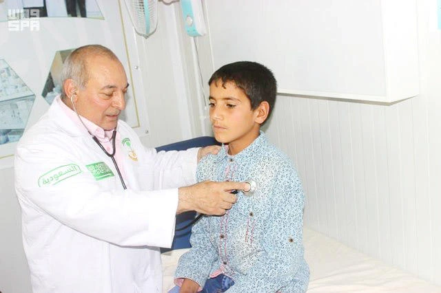 A boy is treated by a physician at a medical center run by the Specialized Saudi Clinics at Zaatari camp in Jordan. (SPA)