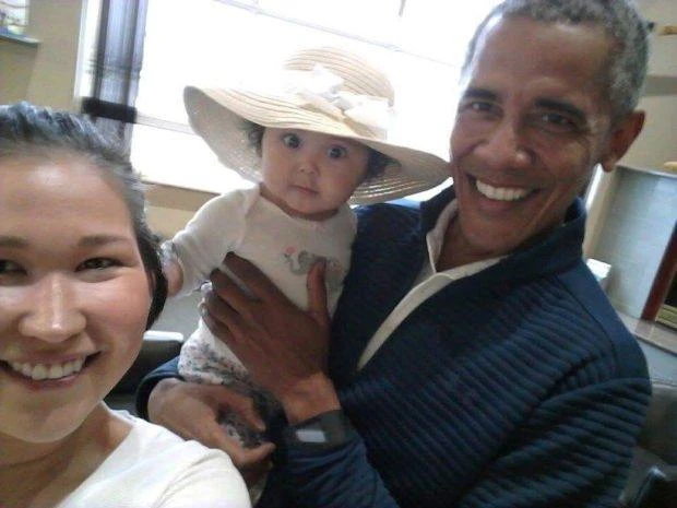 In this July 3, 2017 photo provided by Jolene Jackinsky, former U.S. President Barack Obama holds Jackinsky’s 6-month-old baby girl while posing for a selfie with the pair at a waiting area at Anchorage International Airport, in Anchorage, Alaska. Jackinsky said Obama walked up to her and asked, “Who is this pretty girl?” (Jolene Jackinsky via AP)