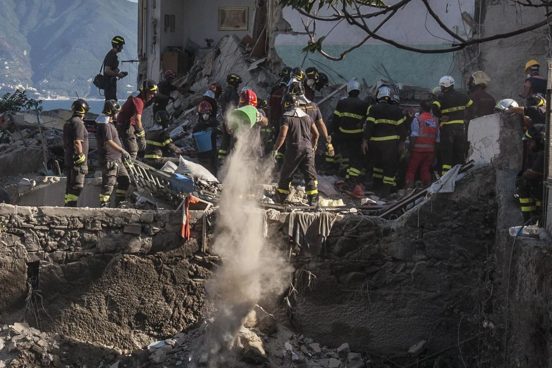 Firefighters throw away the debris of a collapsed building on the binaries of the railway after two floors collapsed in a small four-storey building in Torre Annunziata, a town near the Italian city of Naples, on July 7, 2017. Eight people were missing after the accident. The incident happened in Torre Annunziata at the foot of the volcano Mount Vesuvius. (AFP)