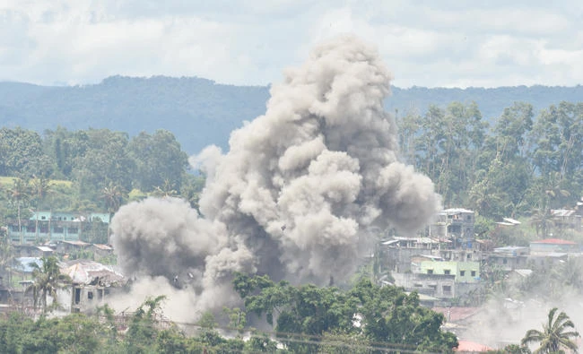 Black smoke billows from burning houses after Philippine airforce attack planes dropped bombs during the an aerial bombing at militants' position in Marawi in this file photo. (AFP)