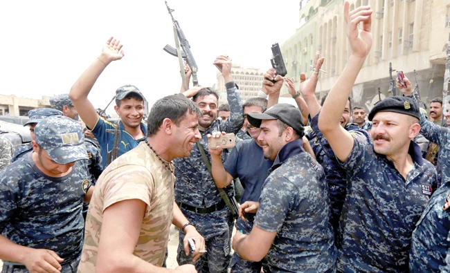 Iraqi police celebrate in the Old City of Mosul. (Reuters)