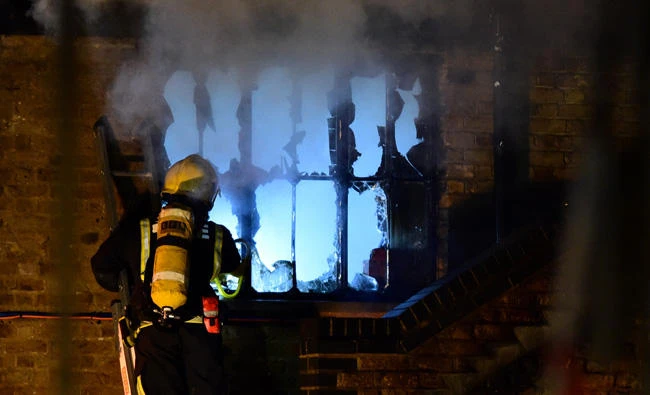 A firefighter tackles a fire at Camden Market in north London on Monday. (REUTERS/Hannah McKay)