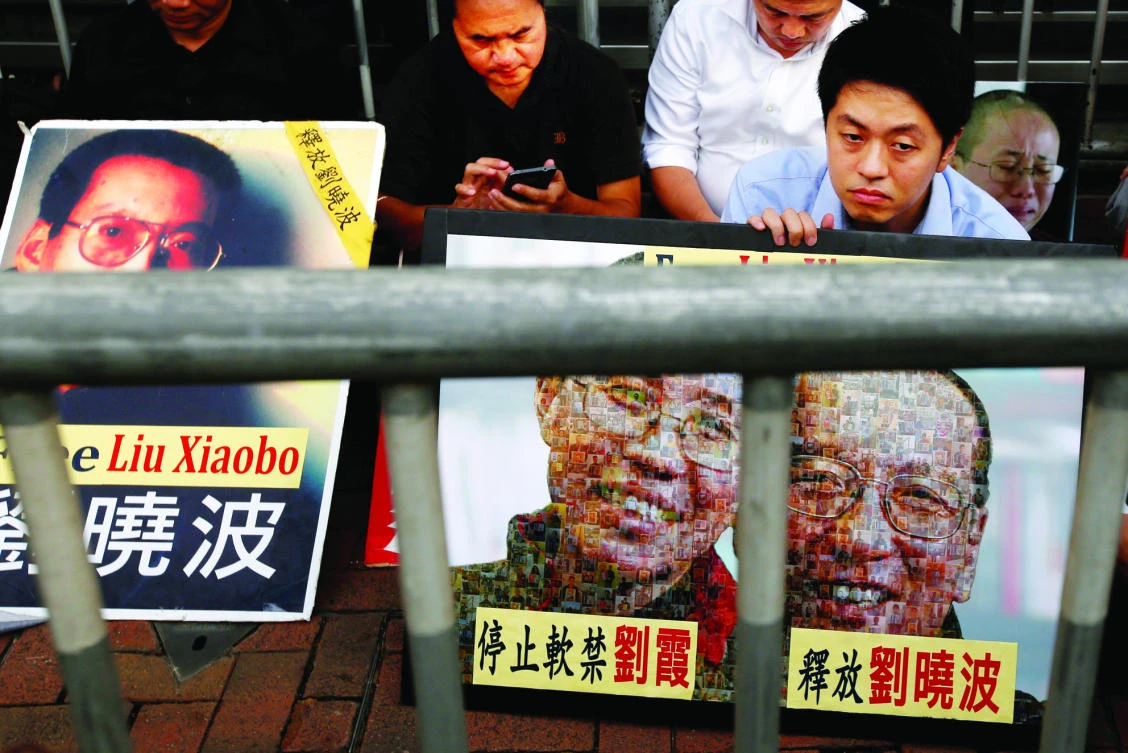 Pro-democracy activists stage a sit-in protest demanding the release of Nobel laureate Liu Xiaobo, outside China's Liaison Office in Hong Kong on Monday. (Reuters)