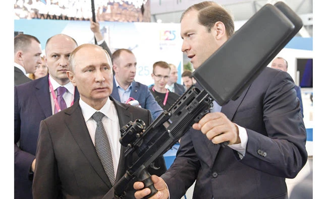 Russian Industry and Trade Minister Denis Manturov, right, shows an exhibit to President Vladimir Putin at an industrial trade fair in Yekaterinburg, Russia, Monday. (AP)