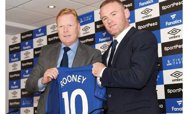 Everton’s new signing, English striker Wayne Rooney, right, poses for a photograph with his new club shirt, held by Everton’s Dutch manager Ronald Koeman, during a press conference at Goodison Park in Liverpool on Monday, following Rooney's move to Everton from Manchester United. (AFP)