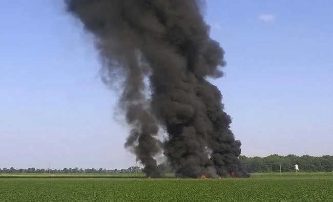 In this photo provided by Jimmy Taylor, smoke and flames come from the wreckage after a military transport airplane crashed in a field near Itta Bena, Mississippi, on the western edge of Leflore County, Monday, killing several. (Jimmy Taylor via AP)