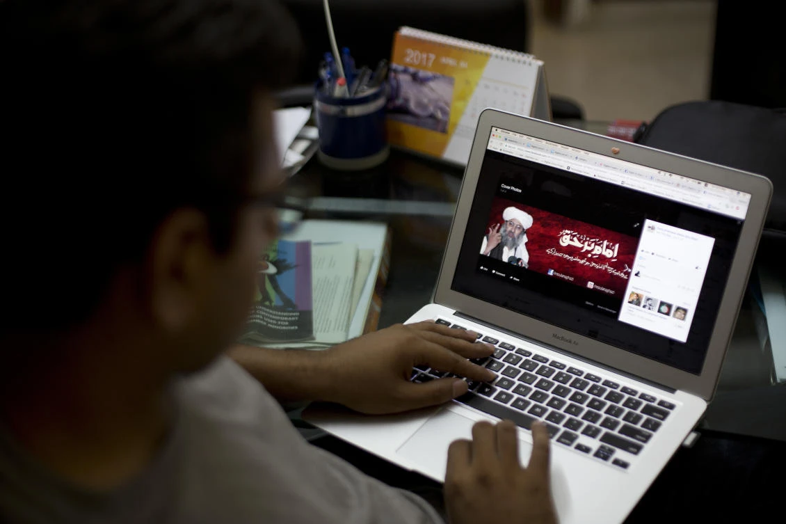 In this Friday, July 7, 2017 photo, Haroon Baloch, a Pakistani social media rights activist looks at a Facebook page of a religious group, that refers to their leader as a "true leader," in Islamabad, Pakistan. A senior Pakistani government official said more than 40 of 65 organizations banned in Pakistan operate flourishing social media sites, communicating on Facebook, Twitter, WhatsApp and Telegram to recruit, raise money and demand a rigid Islamic system. Meanwhile Pakistan is waging a cyber war against activists and journalists who use social media to criticize the government and its agencies. (AP)