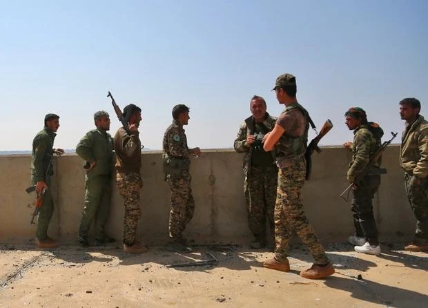 Members of the US-backed Syrian Democratic Forces (SDF) near the Tabqa dam on 28 March (AFP)