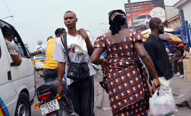 In this file photo, People walk in a street of Kinshasa on January 23, 2015 after days of violent protests against President Joseph Kabila. (AFP)