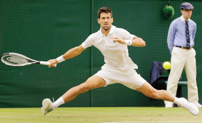 Serbia’s Novak Djokovic stretches to return the ball to Adrian Mannarino of France during their men’s singles match on day eight at the Wimbledon Tennis Championships in London Tuesday. (AP)