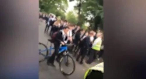 Gangs of teenagers stand outside school allegedly taunting Muslim student. (YouTube)