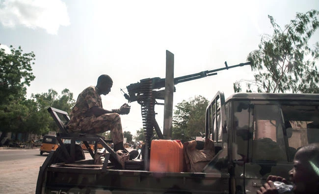 A boy looks on as a soldier sits on the back of an armed vehicle in Maiduguri in north-eastern Nigeria recently. (AFP)