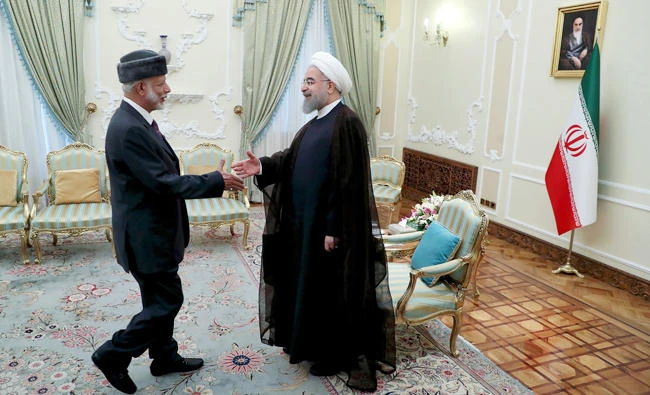 Iranian President Hassan Rouhani, right, welcomes Omani Foreign Minister Yousuf bin Alawi for their meeting in Tehran, Iran on Wednesday. (AP)