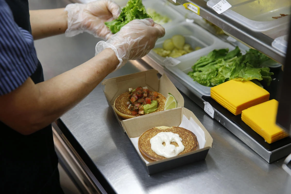 In this Thursday, June 1, 2017, photo, Silvia Ruiz prepares a specialty sandwich at a McDonald's restaurant in Chicago. The company that helped define fast food is making supersized efforts to reverse its fading popularity and catch up to a landscape that has evolved around it. McDonald’s is still trying to shake its image for serving junk food and has made a high-profile pledge to offer healthier options. (AP)