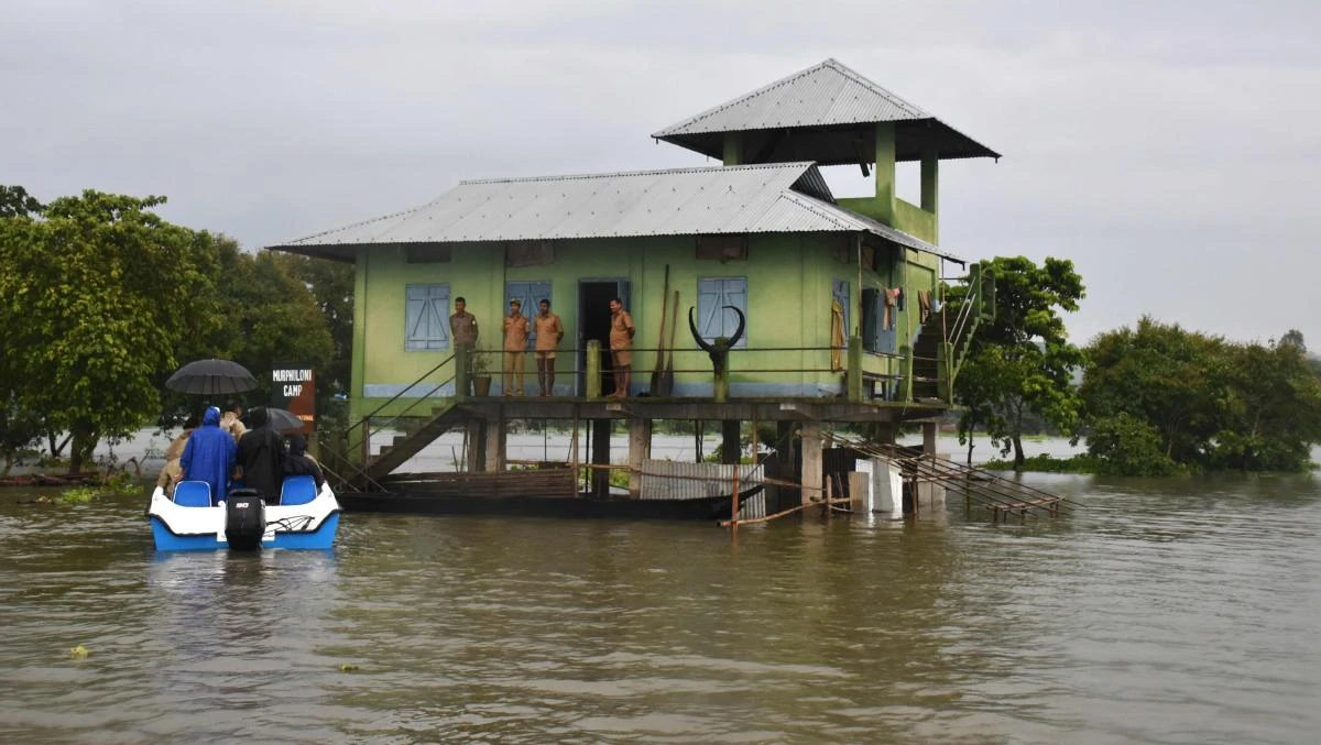 Indian forest officials talk with forest guards at a flooded anti-poaching camp in the Kaziranga National Park, about 250 kilometres east of Guwahati, on July 10, 2017. (AFP)