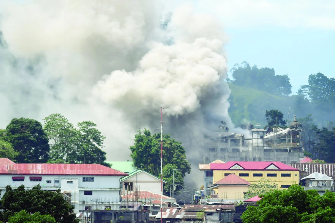 A June 26 file photo shows smoke billowing from a building following an bombing run against militant positions by a Philippine Air Force FA-50 fighter aircraft in Marawi on the southern island of Mindanao. (AFP)