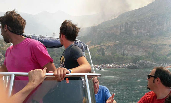 Tourists on a boat turn around to look at a wild fire after being evacuated from their resort in the Sicilian area of San Vito Lo Capo, near Trapani, southern Italy on July 12, 2017. Wildfires fueled by heat and winds have been blazing across much of southern Italy, encroaching on the Amalfi coast and elsewhere. (AP)