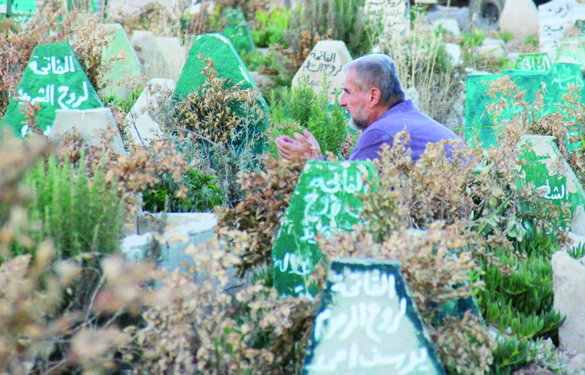 A Syrian man prays at a cemetary in Khan Sheikhun, a rebel-held town in the northwestern Syrian Idlib province, 100 days following a suspected toxic gas attack that was reported to have killed 88 people, including 31 children. (AFP)