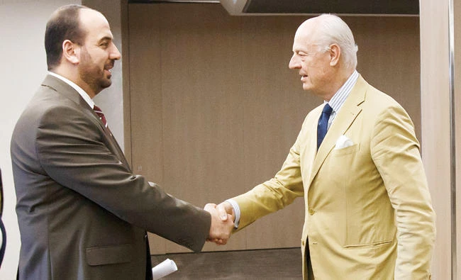 Nasr Al-Hariri, left, shakes hands with Staffan de Mistura, prior a round of negotiation, during the Intra Syria talks, at the European headquarters of the UN in Geneva on Wednesday. (AP)