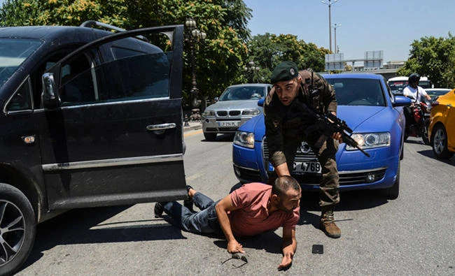 A Turkish police restrains a man on the ground during an operation in front of the courthouse in Ankara. (AFP file)