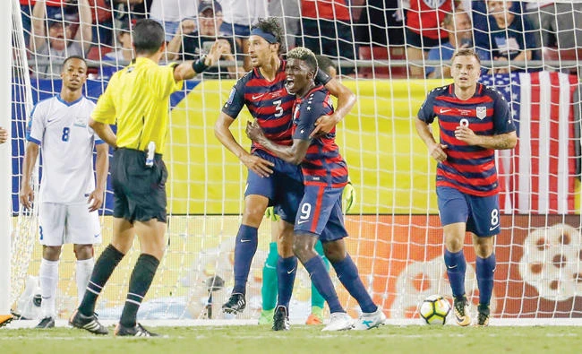 Omar Gonzalez (3) of the US celebrates his goal with teammate Gyasi Zardes (9) as Jordan Morris (8) looks on and Jordy Delem (8) of Martinique reacts during the second half of the CONCACAF Group B match at Raymond James Stadium on Wednesday in Tampa, Florida. (AFP)