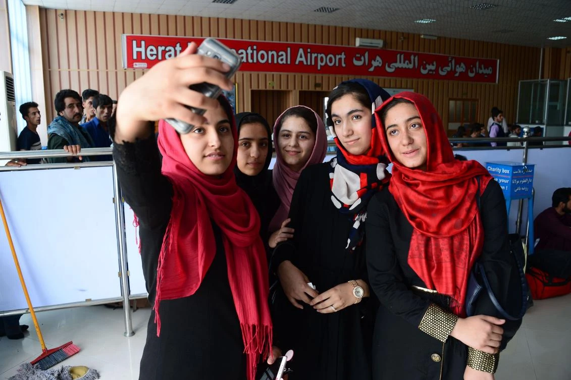 Afghan teenagers from the Afghanistan Robotic House take pictures with a mobile phone at Herat International Airport on July 13, 2017, before embarking for the United States. A team of Afghan girls who had been denied visas to attend a Washington robotics competition are now allowed to come, organizers said July 13. (AFP)
