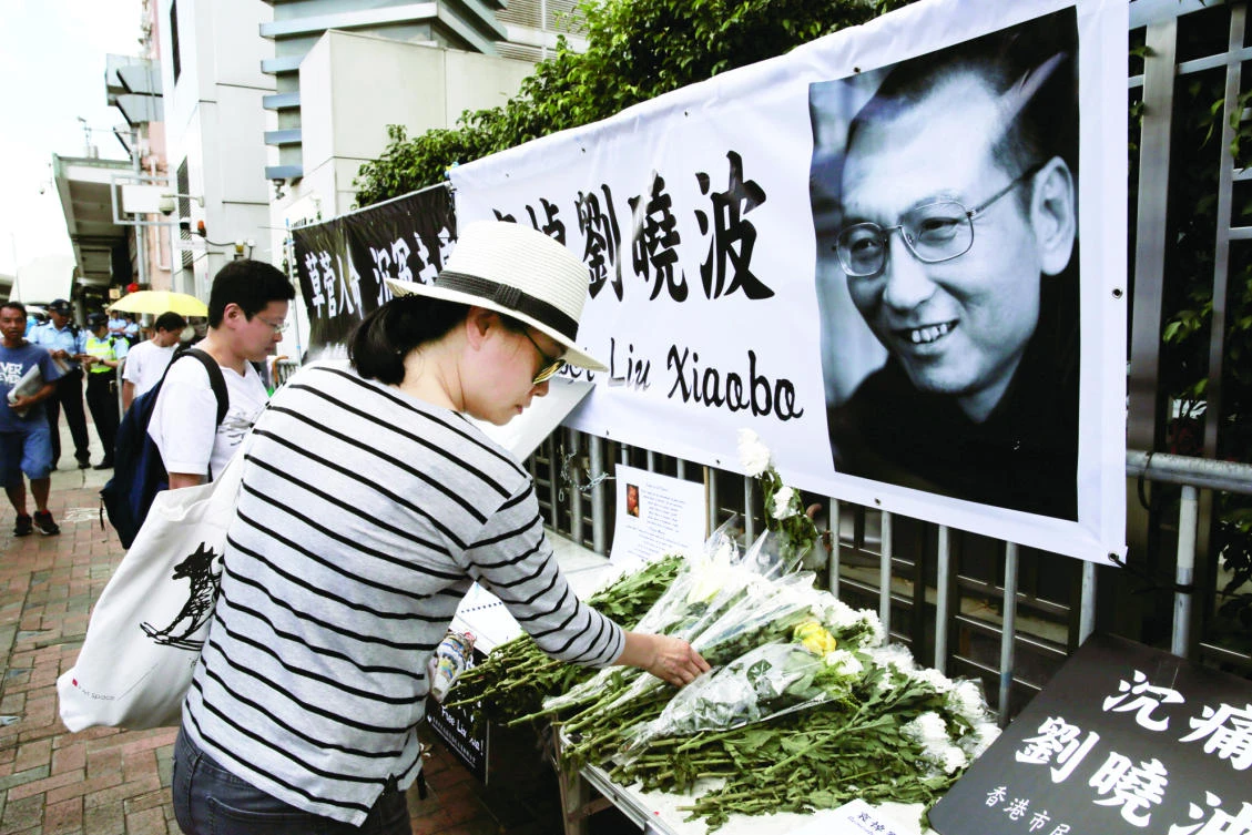A woman mourns Chinese Nobel Peace laureate Liu Xiaobo outside the Chinese liaison office in Hong Kong on Friday. (AP)