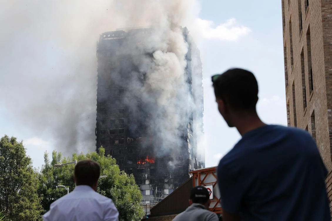 Pedestrians looking up towards Grenfell Tower. (AFP)