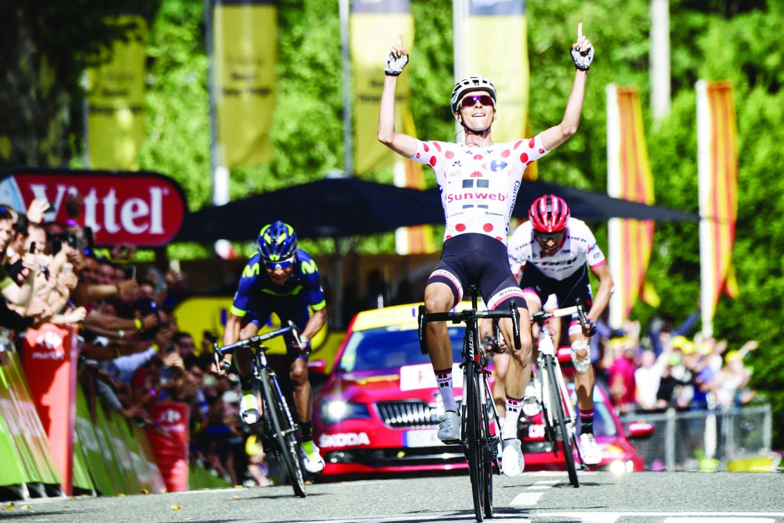 Warren Barguil, wearing the best climber's polka dot jersey, celebrates as he crosses the finish line ahead of Nairo Quintana, left, and Alberto Contador, right, at the end of the 101 km 13th stage of the Tour de France on Friday. (AFP)
