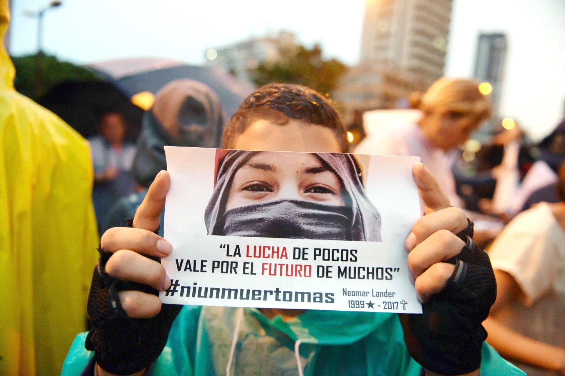 An opposition activist holds a sign reading “The fight of few is for the future of many” during a protest against Venezuelan President Nicolas Maduro in Caracas on Thursday. (AFP)