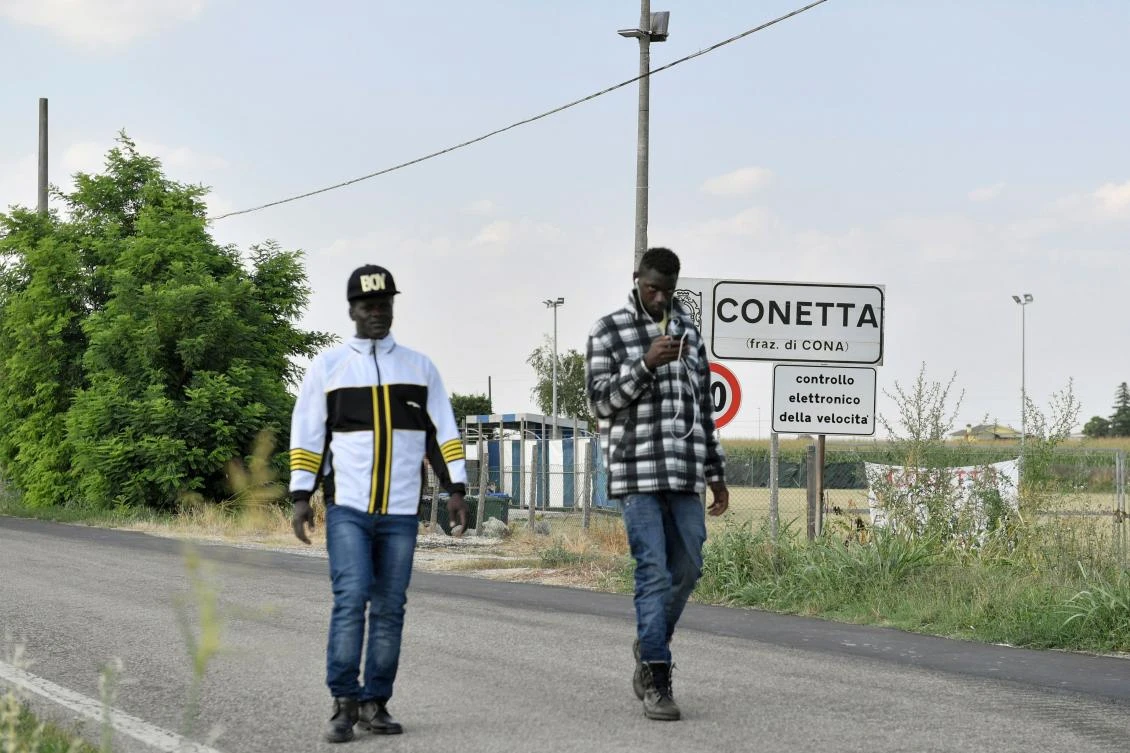 Migrants walk on a path near the Cona reception centre, near Padua, on July 10, 2017. (AFP)