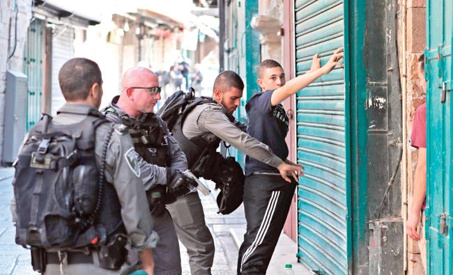 Israeli security forces frisk a Palestinian youth in Jerusalem’s Old City on Friday following the attack. (AFP)