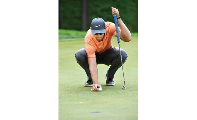 Patrick Rodgers places his ball while reading the green
on the ninth hole during the second round of the John Deere Classic golf tournament. (AP)